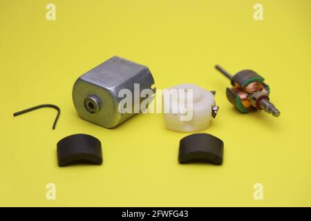 Zerlegen des dc-Elektromotors mit allen seinen Teile auf gelbem Hintergrund isoliert Stockfoto