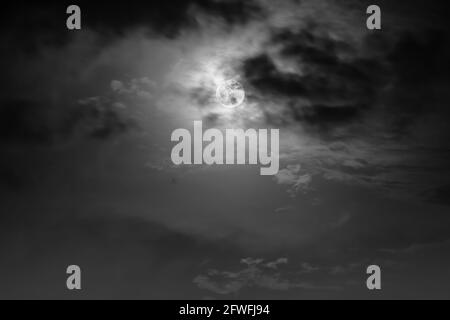 Hintergrund des Nachthimmels mit Wolke und Vollmond mit Glanz. Natürliche Schönheit bei Nacht mit Mond hinter Wolken in Schwarz-Weiß-Stil. Vintage-Effekt Stockfoto