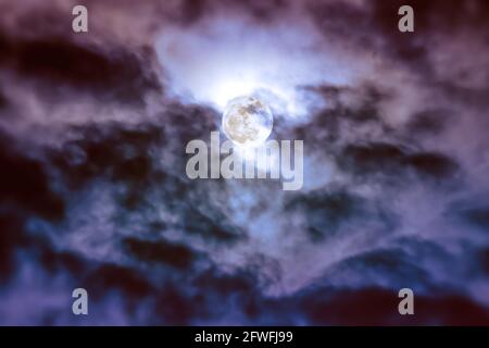 Attraktives Foto von Hintergrund Nachthimmel mit Wolken und hellen Vollmond mit glänzend. Nachthimmel mit wunderschönem Vollmond hinter Wolken. Im Freien Stockfoto