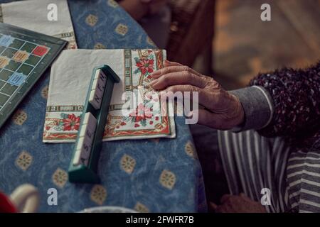 Reife Hände mit Arthritis, spielen Buchstaben Spiel Stockfoto