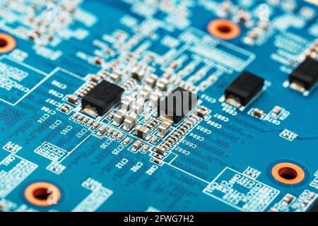 Chips und Mikroprozessoren auf der blauen Grafikkarte. Komponenten und elektronische Teile für PC-Reparatur, Reparatur und Wartung Stockfoto