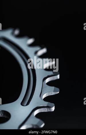 Sternenzähnchen-Muster mit Fahrradketten-Mechanismen auf schwarzem Hintergrund. Dark Key, Draufsicht Black Star Pleuelsystem für schmale breite Fahrräder. Stockfoto