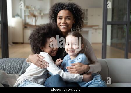 Portrait der biracial Mutter Entspannen Sie sich mit multiethnischen Töchtern Stockfoto