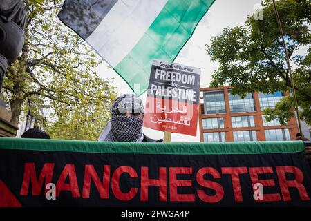 Manchester, Großbritannien. Mai 2021. Ein Protestler steht hinter einem Transparent mit der Aufschrift: Manchester, vor Beginn des marsches, während einer Demonstration der Freien Palästinas. Trotz einer Waffenruhe über den Gazastreifen dauern die Proteste weltweit an.die Proteste wurden ausgelöst, nachdem israelische Truppen versucht hatten, Demonstranten aus dem Dorf Sheikh Jarrah zu bewegen, wo Familien aufgrund der Landbesetzung vertrieben wurden. Kredit: SOPA Images Limited/Alamy Live Nachrichten Stockfoto