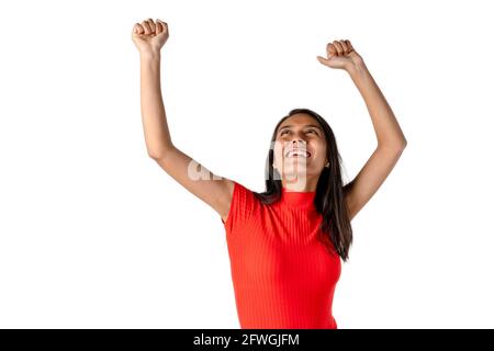 Attraktive lächelnde, dunkelhaarige Latina-Frau mit offenen Armen, die auf reinem weißen Hintergrund ihre persönliche Leistung feiert. Stockfoto