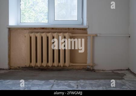 Gusseiserne Batterie zur Warmwasserbereitung an der Wand. Stockfoto