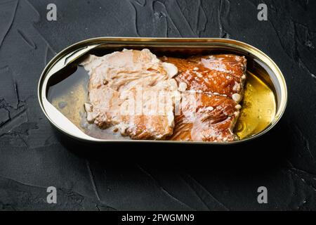 Geräucherter Lachsfilet Fischkonserven-Set, in Zinndose, auf schwarzem Hintergrund Stockfoto
