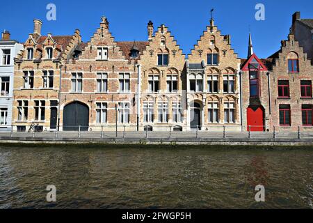 Malerischer Blick auf malerische viktorianische und gotische Gebäude im neugotischen Stil mit Backsteinfassaden und spitzen Dächern entlang des Dijver-Kanals in Brügge, Belgien. Stockfoto