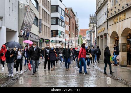 Münster, NRW, Deutschland. Mai 2021. In der Altstadt von Münster versammeln sich trotz heftigem Regen Menschenmassen, denn es wird die erste Stadt in Nordrhein-Westfalen, in der es möglich ist, Indoor-Trink- und Gastronomiebereiche (mit negativem Test oder Impfung) und Shopping ohne Test oder Termin (aber die Anzahl ist begrenzt) zu eröffnen. Münster hat derzeit mit 17/100k eine der niedrigsten covid-Inzidenzraten in NRW und hat sich zu einer „Modellregion“ entwickelt, um eine langsame Wiedereröffnung von Hospitality-Locations zu testen. Kredit: Imageplotter/Alamy Live Nachrichten Stockfoto