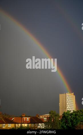 Wimbledon, London, Großbritannien. 22 Mai 2021. Der heftige Abendregen endet mit einem hellen doppelten Regenbogen über den Häusern in einem Vorort Londons. Der Goldtopf am Ende des Regenbogens ist das Büro im Londoner Stadtteil Merton Civic Center. Quelle: Malcolm Park/Alamy Live News. Stockfoto