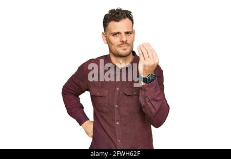 Junger hispanischer Mann in legerer Kleidung mit italienischer Geste mit Hand und Fingern selbstbewussten Ausdruck Stockfoto