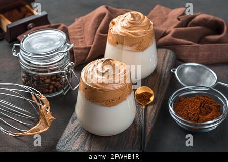 Zwei Gläser Dalgona-Kaffee auf braunem Hintergrund. Ein traditionelles koreanisches Getränk. Speicherplatz kopieren. Stockfoto