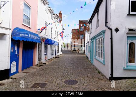 Lymington Hampshire – farbenfroh gerenderte Wände und Erkerfenster Ladenfronten entlang der hügeligen, gepflasterten Quay Street in England - Mai 2021 Stockfoto