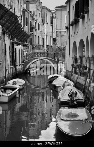 Kanal in Venedig mit festfahrten Booten, Italien. Schwarzweiß-Fotografie, venezianische Ansicht Stockfoto