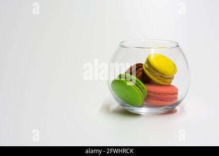 Bunte Makronen in einem Glas Küchenglas auf einem weißen Hintergrund Stockfoto