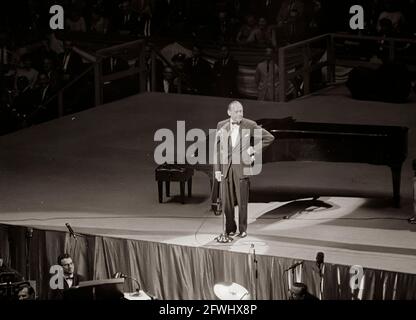 Der Komiker Jack Benny tritt bei einem Spendenessen der Demokratischen Partei und einem Geburtstagsgruß an Präsident John F. Kennedy im Madison Square Garden in New York City, New York, auf. Stockfoto