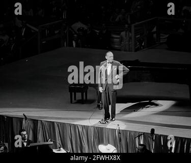 Der Komiker Jack Benny tritt bei einem Spendenessen der Demokratischen Partei und einem Geburtstagsgruß an Präsident John F. Kennedy im Madison Square Garden in New York City, New York, auf. Stockfoto