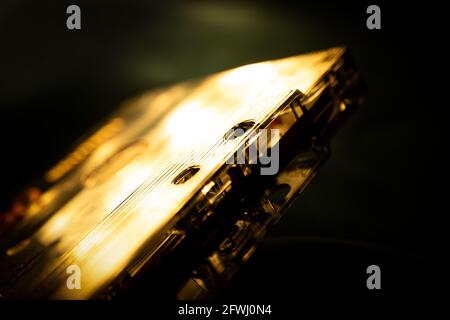 Sepia-getönte Makroansicht der Ecke des abgewinkelten Kassettenbandes Isoliert auf schwarzem und grünem Hintergrund Stockfoto