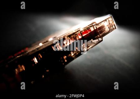 Minimalistische Nahaufnahme des roten Klebebands auf der Unterseite des abgewinkelten durchsichtigen Klebebands Kassette Stockfoto