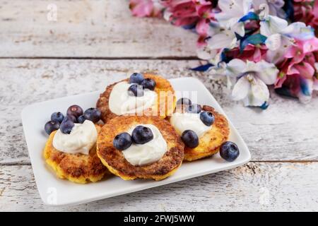 Pfannkuchen aus Quark mit saurer Rahm und frischen Blaubeeren. Nahaufnahme. Stockfoto