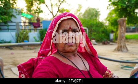 Nahaufnahme einer indischen frau im alter von rajasthani. Entspannende indische Stammesfrau mit ihrem traditionellen Turban und ihrem Dressing Stockfoto