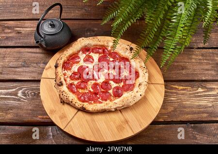 Pepperoni Pizza auf einem Holzständer Stockfoto