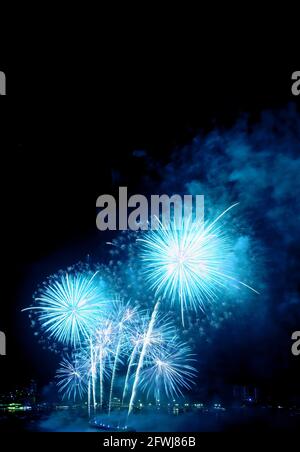 Fantastisches, lebendiges blaues Feuerwerk, das in den Nachthimmel übergeht Der Hafen Stockfoto
