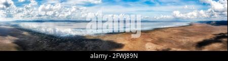 Breites Luftpanorama vom Lake George in NSW, Australien in Richtung Windfarm an einem sonnigen bewölkten Tag. Stockfoto