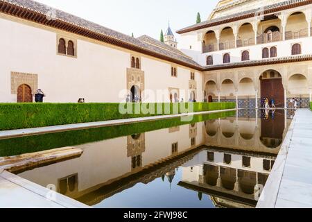 Maskierte Touristen besuchen den Comares Palast der Alhambra in Granada. Stockfoto