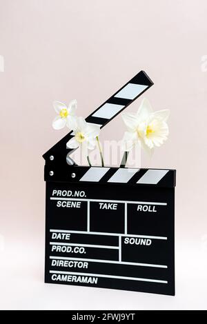 Klappbrett aus Film mit Frühlingsblumen. Minimale Standzeit der Klapptafel für die Herstellung von Video-Kino und Narzissen Blumen. Stockfoto