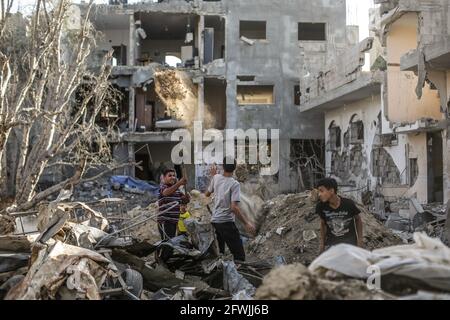 Palästinensische Kinder spielen in der Stadt Beit Hanoun im nördlichen Gazastreifen in den Trümmern ihrer zerstörten Häuser nach dem Waffenstillstand zwischen Israel und Aktivisten des Gazastreifens. Nach 11 Tagen der Kämpfe trat der Waffenstillstand zwischen Israel und den Aktivisten im Gazastreifen unter der Aufsicht einer ägyptischen Initiative zur Beendigung des bedingungslosen Feuers in Kraft. Nach Angaben des palästinensischen Gesundheitsministeriums wurden bei dem israelischen Angriff mindestens 232 Palästinenser getötet, während mindestens 12 Israeliten bei Raketenangriffen aus Gaza getötet wurden. Stockfoto