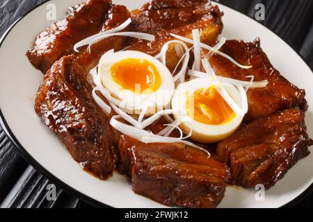 Japanischer Schweinebauch mit gekochten Eiern in der Nähe auf dem Teller auf dem Tisch. Horizontal Stockfoto