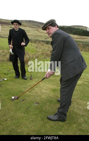 Harry (flache Mütze) und Alfie (gebrandter Hut) ward in zeitgemässen Kostümen auf ihrem Golfplatz im Stil der 1890er Jahre in Abington, Schottland. Stockfoto