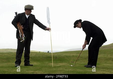 Harry (flache Mütze) und Alfie (gebrandter Hut) ward in zeitgemässen Kostümen auf ihrem Golfplatz im Stil der 1890er Jahre in Abington, Schottland. Stockfoto