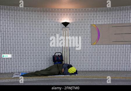 Ein Obdachloser schläft in der Hamamatsu Station, Hamamatsu, Shizuoka. Stockfoto