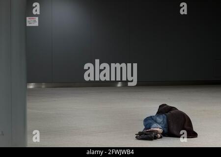 Marunouchi, Japan. Januar 2015. Ein japanischer Obdachloser schläft auf dem Boden in den Einkaufspassagen unter dem Bahnhof Tokio. (Foto von Damon Coulter/SOPA Images/Sipa USA) Quelle: SIPA USA/Alamy Live News Stockfoto