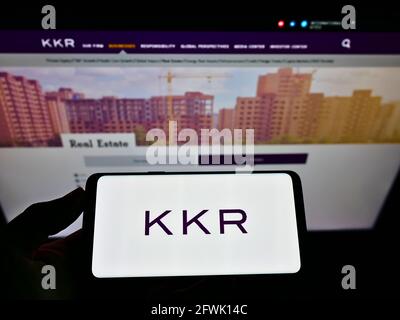 Person, die das Smartphone mit dem Logo der US-Investmentfirma KKR Co. Inc. Auf dem Bildschirm vor der Website hält. Konzentrieren Sie sich auf die Telefonanzeige. Stockfoto