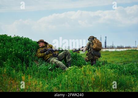 Airsoft-Spieler verstecken sich während des Kampfes in hinter der Abdeckung Das Feld Stockfoto