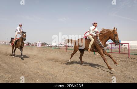 Khadal, Oman, 28. April 2018: omanische Männer in traditioneller Kleidung, Pferde reiten Stockfoto