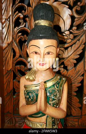 Buddhistische Statue eines Mädchens auf einem Holzhintergrund Stockfoto