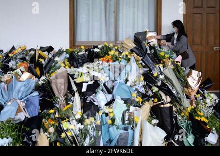 Changsha, Chinas Provinz Hunan. Mai 2021. Ein Bürger überreicht Blumen, um dem verstorbenen Wissenschaftler Yuan Longping in der Mingyangshan-Trauerhalle in Changsha, der zentralchinesischen Provinz Hunan, zu ehren, 23. Mai 2021. Quelle: Chen Zhenhai/Xinhua/Alamy Live News Stockfoto