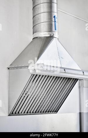 Dunstabzugshaube in der Produktionshalle. Installation eines Lüftungssystems in Industrieräumen Stockfoto