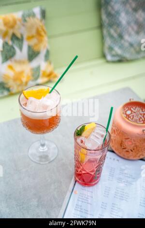 Zwei rosarote Cocktails, die draußen auf einer sonnigen Terrasse serviert werden, vertikal, keine Menschen Stockfoto