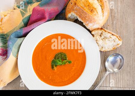 Kürbissuppe in weißer Schüssel mit mehrkörnigem Brötchen Stockfoto