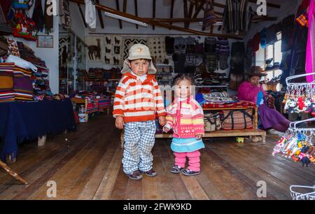 Süße lokale Quechua-Kinder in einem Geschäft in Chinchero, einem kleinen rustikalen Dorf der Anden im Heiligen Tal, Provinz Urubamba, Region Cusco, Peru Stockfoto