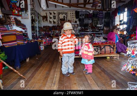 Süße lokale Quechua-Kinder in einem Geschäft in Chinchero, einem kleinen rustikalen Dorf der Anden im Heiligen Tal, Provinz Urubamba, Region Cusco, Peru Stockfoto