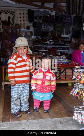 Süße lokale Quechua-Kinder in einem Geschäft in Chinchero, einem kleinen rustikalen Dorf der Anden im Heiligen Tal, Provinz Urubamba, Region Cusco, Peru Stockfoto