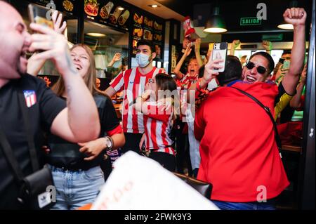 Madrid, Spanien. Mai 2021. Fans von Atletico de Madrid feiern den Sieg des Teams beim La Liga-Titel 2020-2021 in einer Bar in Madrid, Spanien, am 22. Mai 2021. Atletico Madrid wurde mit einem Sieg von 2-1 in Valladolid an einem dramatischen Samstagnachmittag zum Meister der Liga für die Saison 2021-22 gekrönt. Kredit: Gustavo Valiente/Xinhua/Alamy Live Nachrichten Stockfoto