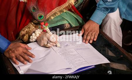 Ein Mädchen, das ihre Ehepapiere unterschrieb, Hochzeiten in Pakistan, pakistanische Ehepapiere, Nikkah Nama. Stockfoto