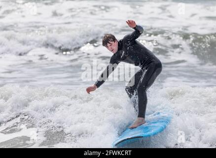 Garrettstown, Cork, Irland. Mai 2021. Ein Sufer versucht, sein Gleichgewicht während der rauen Seebedingungen in Garrettstown, Co. Cork, Irland, zu halten. -Credit; David Creedon / Alamy Live News Stockfoto